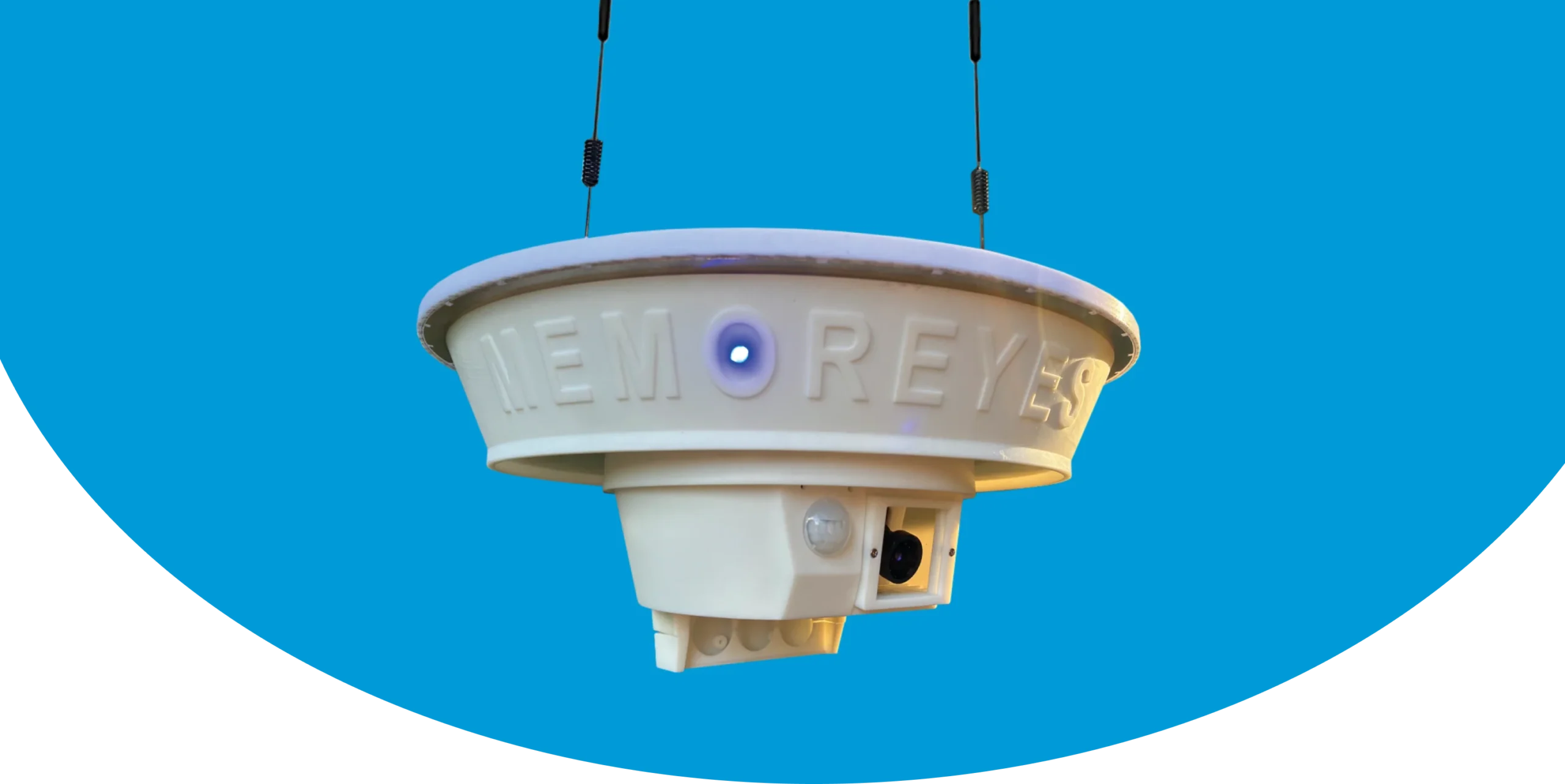 Memoreyes Municipal A white, round, plastic device with a blue light and a black cord, suspended from a blue background